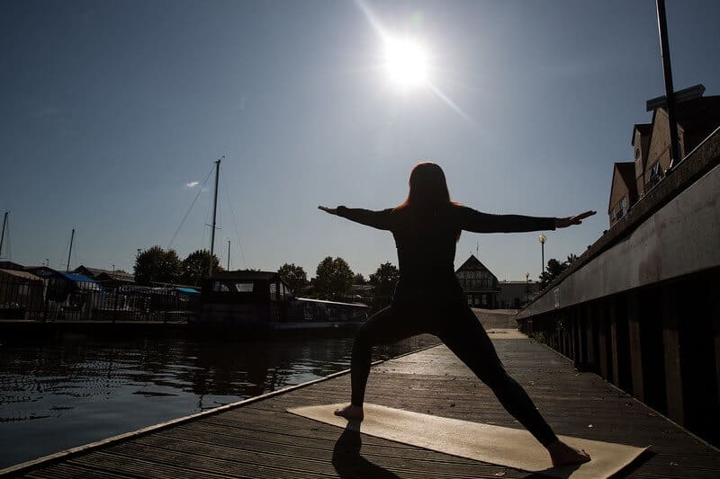Woman Stands In Warrior 2 Pose Outdoors In Bristol